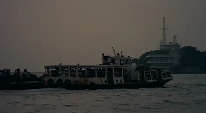 The Boys From Fengkuei (1983) movie still: wide — A white ferry filled with passengers travels across choppy dark water during twilight. A large…