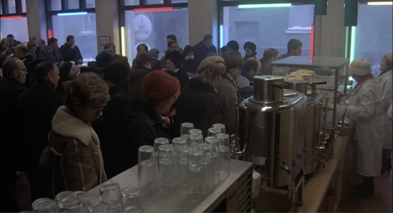 Gorky Park (1983) movie still: medium — A crowded public service counter features long queues of people in winter clothing. Individuals stand…