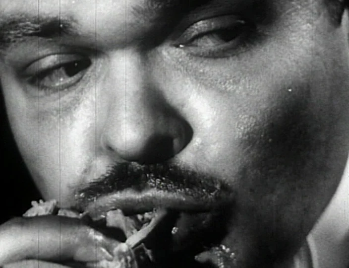 Dementia (Daughter of Horror) (1955) movie still: closeup — A close-up view of a man's face framed within a dark, indistinct interior setting. The…