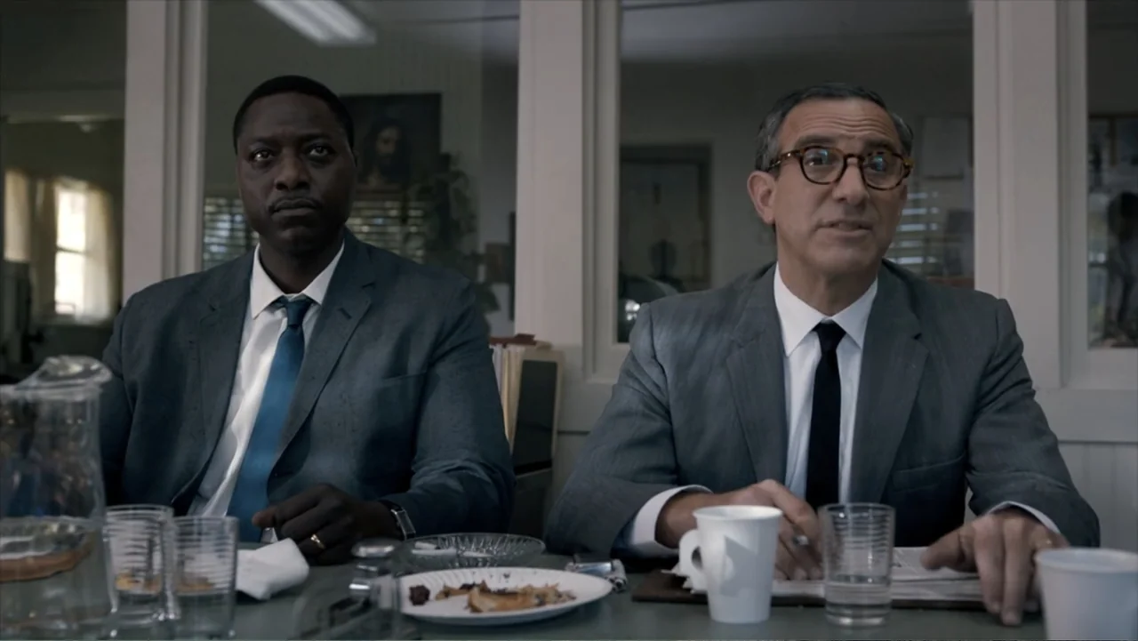 All the Way (2016) movie still: medium — An office interior features light-colored walls, a glass partition, and a table with scattered items. Two…