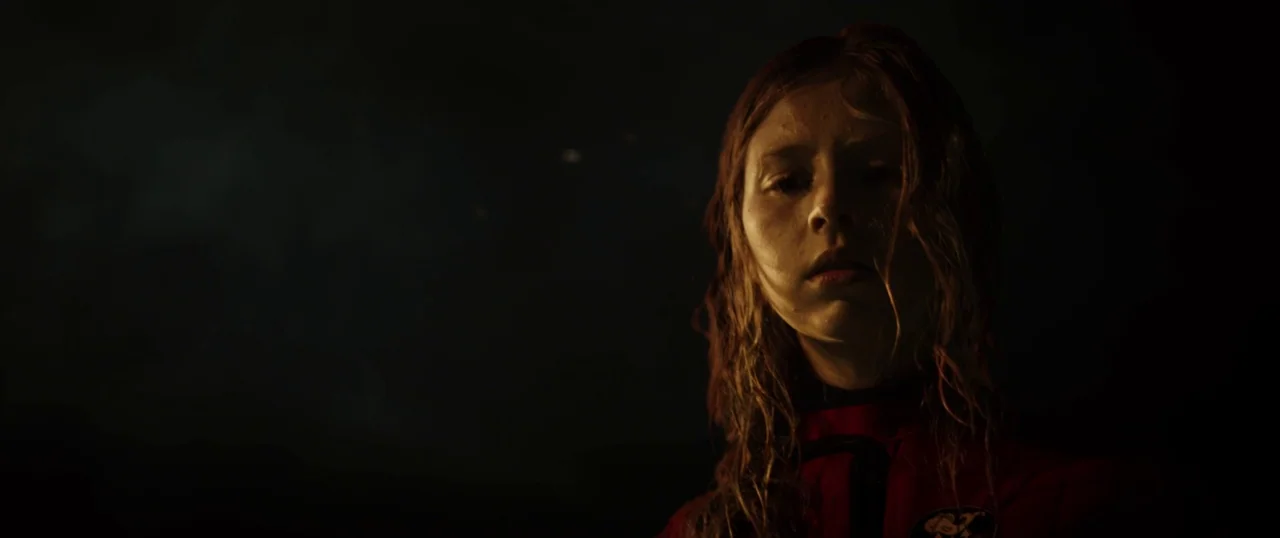 Sea Fever (2019) movie still: closeup — A dark, undefined space with no visible landmarks or architectural features. A young woman with wet hair…