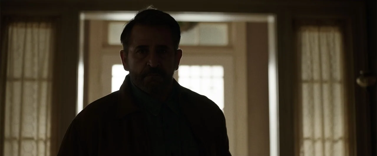 Annabelle: Creation (2017) movie still: medium — A man stands in a dark corridor with a bright window behind him. He is framed by an open doorway…