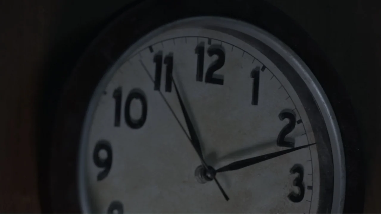The Messenger (2015) movie still: closeup — A close-up view of an analog clock with a white face and black numerals. The hands of the clock point to…