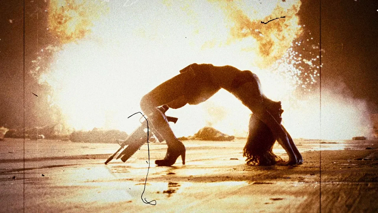 Planet Terror (2007) movie still: fullbody — A dark, flat surface illuminated by a massive, uncontrolled fire explosion in the background. A woman…