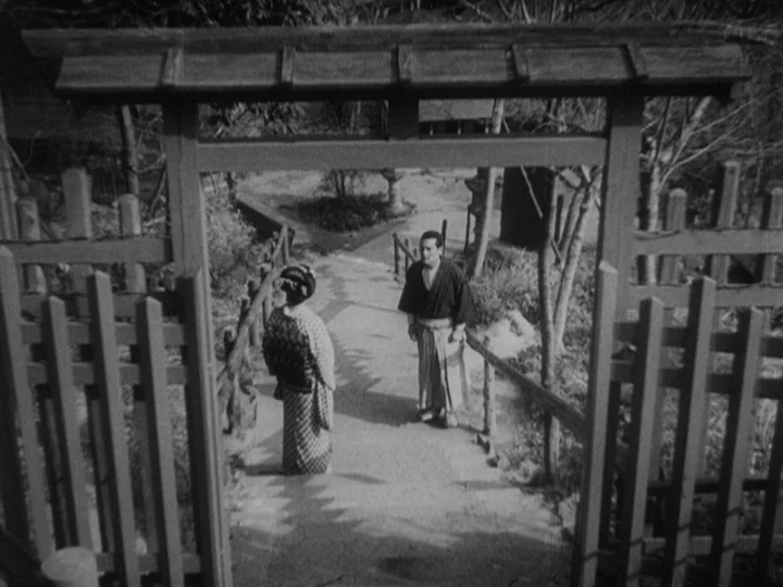 Sanshiro Sugata (1943) movie still: wide — A stone pathway leads downward through a wooden gate in a temple complex. A woman in a kimono and a man…
