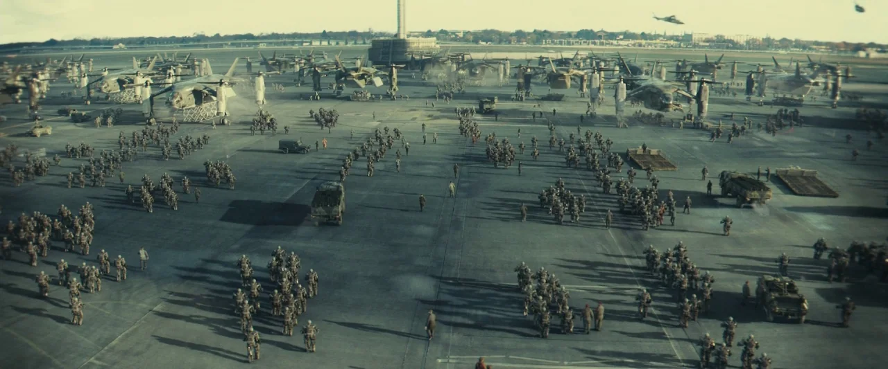 Edge of Tomorrow (2014) movie still: establishing — A vast, expansive military tarmac filled with numerous vertical-takeoff aircraft and marching…