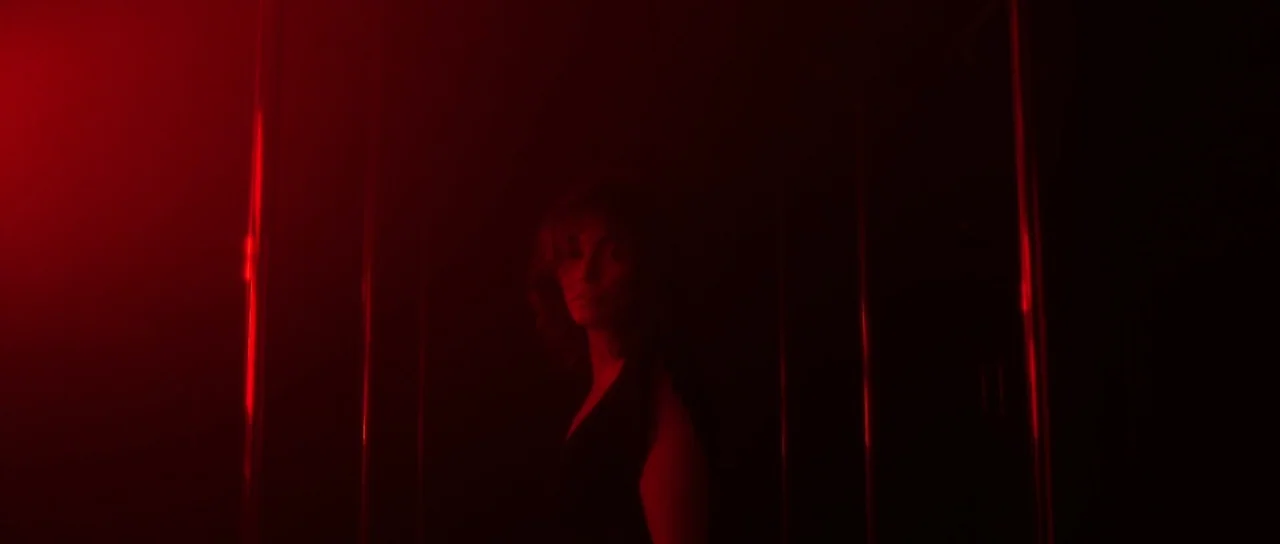 Vinyan (2008) movie still: medium — A dimly lit space features several vertical metal poles reflecting bright red light. A woman stands between the…