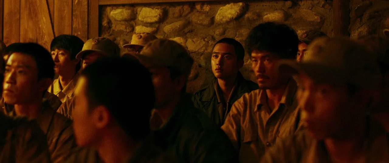 Swing Kids (2018) movie still: medium — A dimly lit room with a rough stone wall and wooden structural beams. A group of men in military uniforms…