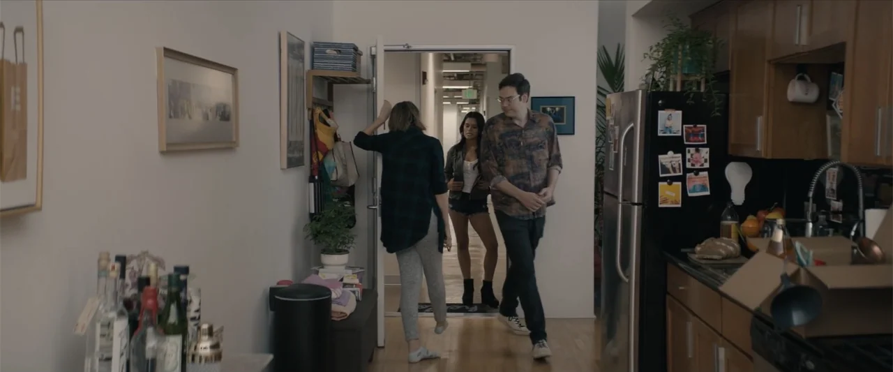 Equation of Love and Tone Deafness (2015) movie still: medium — An apartment entryway connects to an open-plan room with cabinets and kitchen items.…