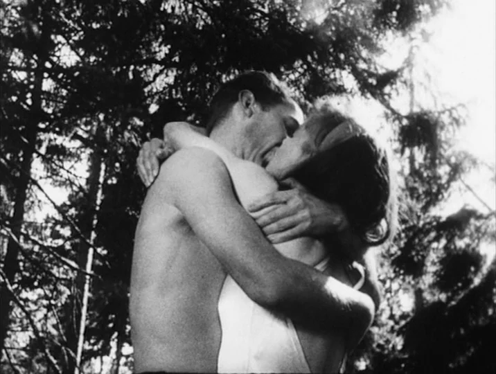 Thirst (1949) movie still: medium — A dense forest environment with sun-dappled foliage visible above and around the subjects. A shirtless man and a…