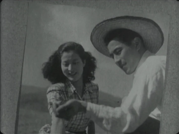 The Quiet Duel (1949) movie still: medium — A black and white photograph depicting a man and a woman in a field. The man wears a straw hat and looks…
