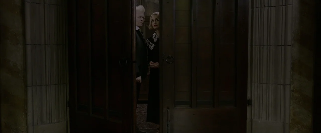 Fantastic Beasts: The Crimes of Grindelwald (2018) movie still: medium — A dark wooden door is slightly ajar in a dimly lit stone building. A man…