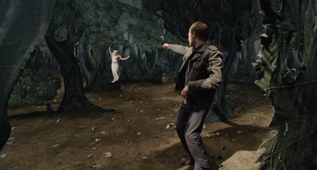 The Imaginarium of Doctor Parnassus (2009) movie still: medium — A theatrical stage set with painted cutouts depicting a dense forest scene. A young…
