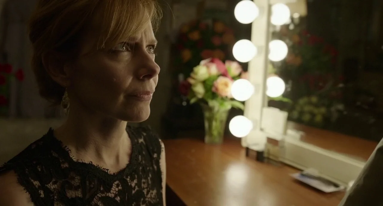 Birdman (2014) movie still: closeup — A dimly lit dressing room features a mirror surrounded by glowing round lightbulbs. A woman with blonde hair…