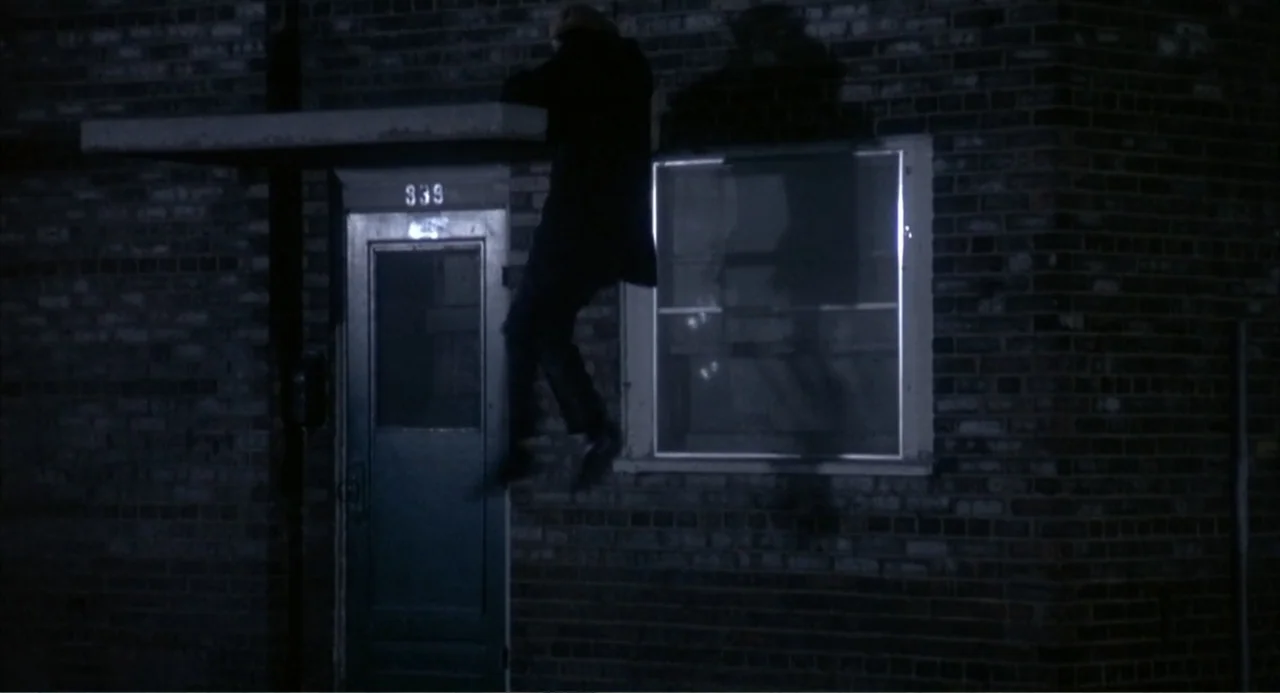 Cooley High (1975) movie still: medium — A dark brick building facade with a door marked with the number 339. A lone figure in dark clothes is…