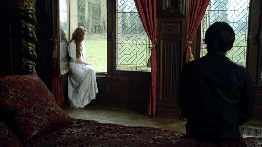 The Sleeping Beauty (2010) movie still: wide — A Victorian-style room features dark wood paneling, leaded glass windows, and heavy red curtains. A…