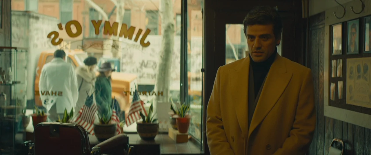 A Most Violent Year (2014) movie still: medium — A vintage-style barbershop with wood paneling and a large glass window facing the street. A man in…