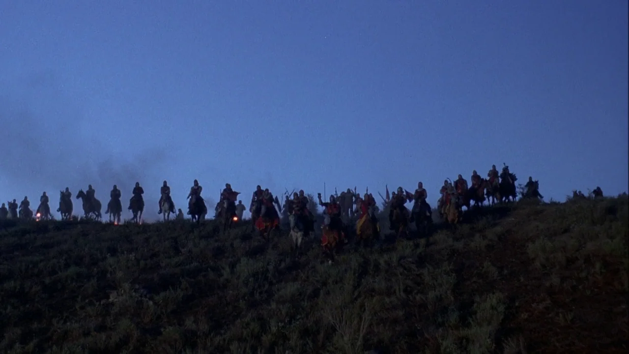 Army of Darkness (1992) movie still: wide — A group of medieval knights on horseback silhouettes against a vast twilight sky on hill. The riders…