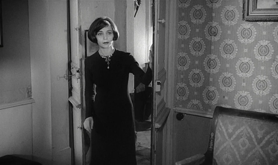 Thérèse Desqueyroux (1962) movie still: medium — A dark, sparsely decorated apartment interior with patterned Victorian-style wallpaper on the wall.…