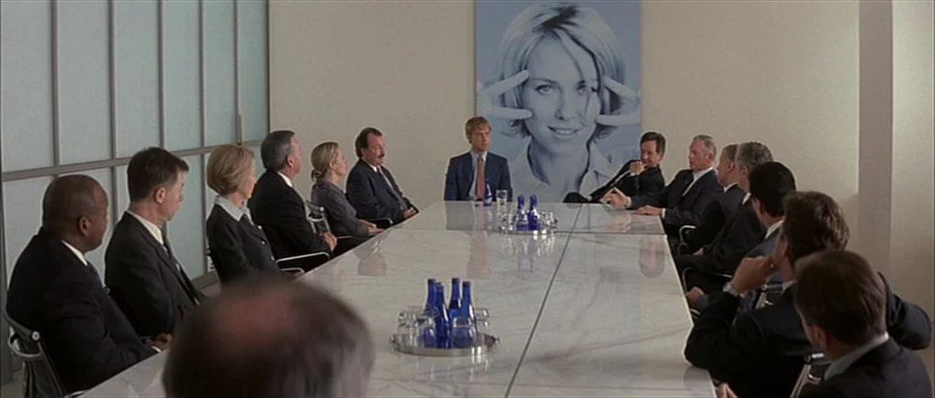 I Heart Huckabees (2004) movie still: wide — A modern boardroom features a long white marble table and a large wall photograph. Business…