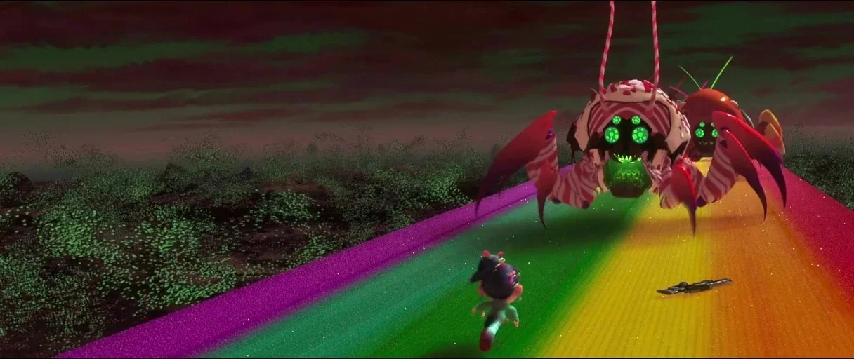 Wreck-It Ralph (2012) movie still: wide — A vibrant rainbow-colored path stretches through a dark, desolate landscape with dark green vegetation. A…