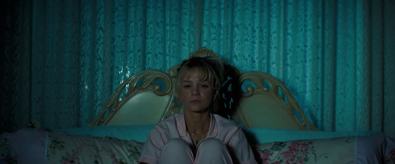 Promising Young Woman (2020) movie still: medium — A bedroom features a decorative headboard and ruffled lace curtains covering a window. A woman…