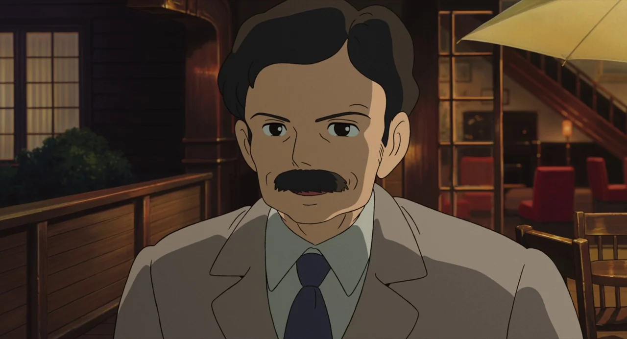 The Wind Rises (2013) movie still: medium — A wooden terrace at night with glowing interior lights visible through a glass wall. A middle-aged man…