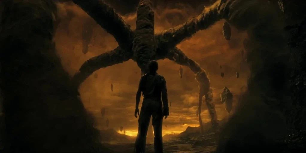 Stranger Things (2016) movie still: wide — A vast, hazy orange wasteland is filled with floating rocky debris and swirling dust. A man stands in the…