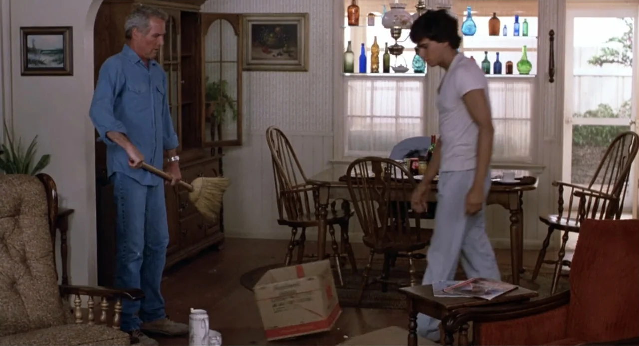 Harry and the Butler (1961) movie still: fullbody — A 1980s suburban home dining area features wallpapered walls, wooden furniture, and decorative…