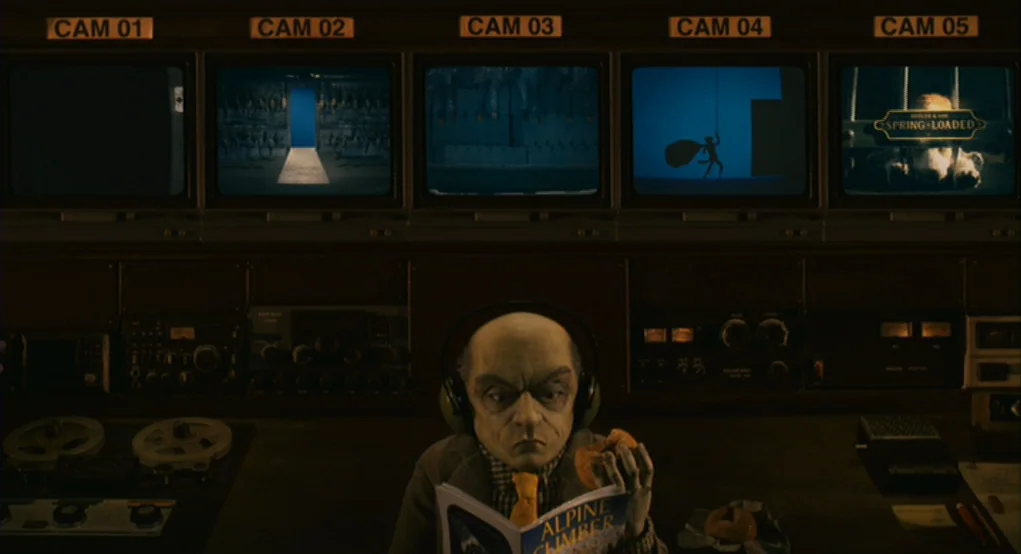 Fantastic Mr. Fox (2009) movie still: medium — A dimly lit security control room features a bank of five video monitors above. A man in a tweed…