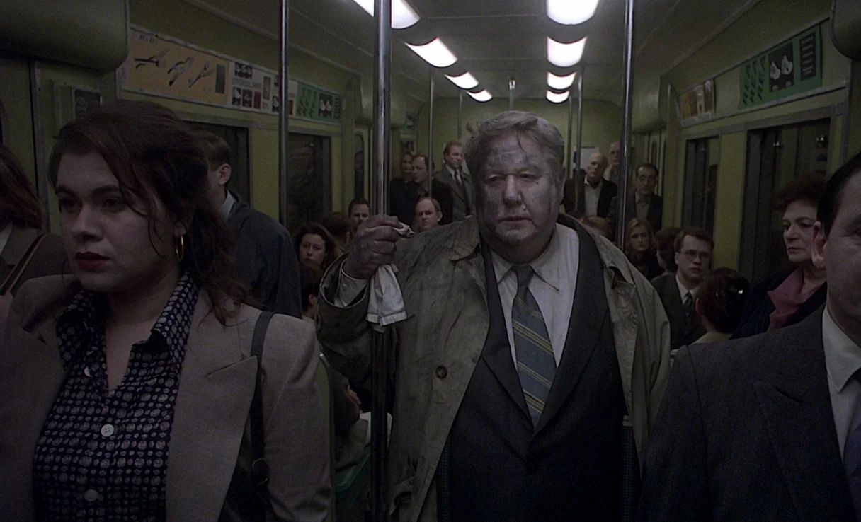Songs from the Second Floor (2000) movie still: medium — A crowded subway car interior features a group of commuters standing between vertical…