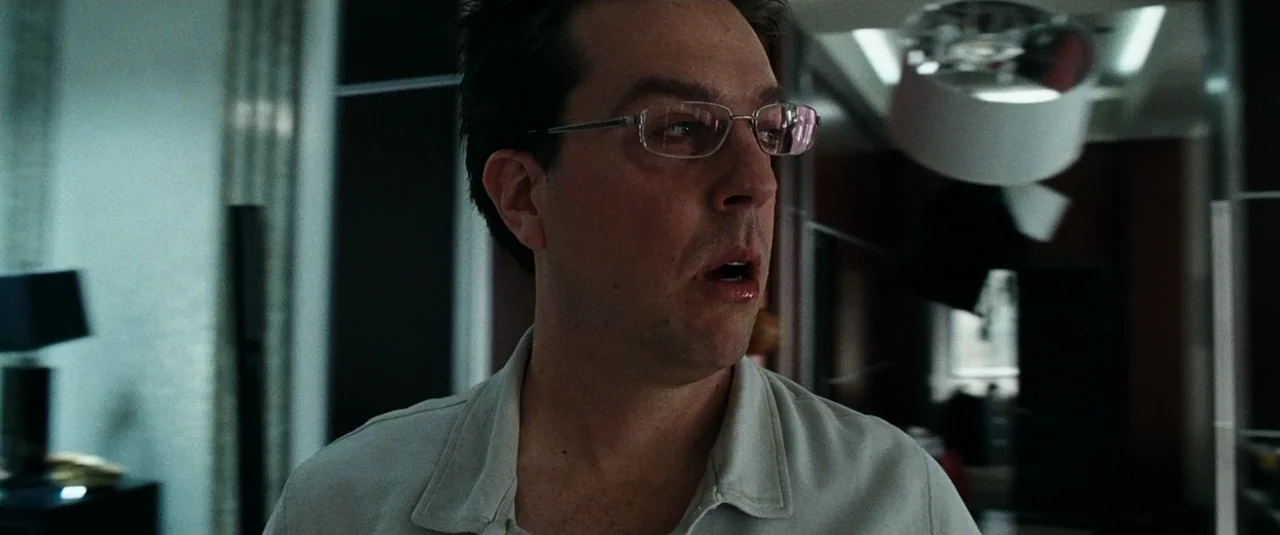 The Hangover (2009) movie still: medium — An interior hotel room features dark modern furniture and overhead lamps with white shades. A man in…