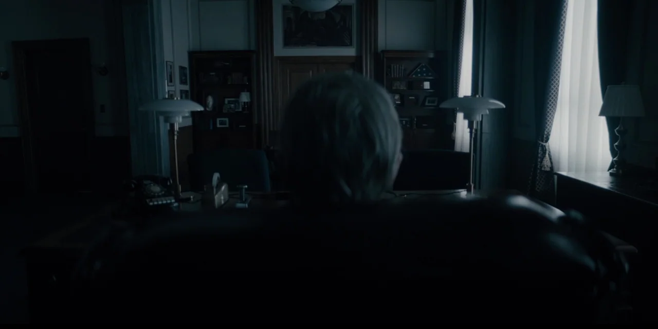Mark Felt: The Man Who Brought Down the White House (2017) movie still: medium — A dimly lit room features a large wooden desk with two brass lamps.…