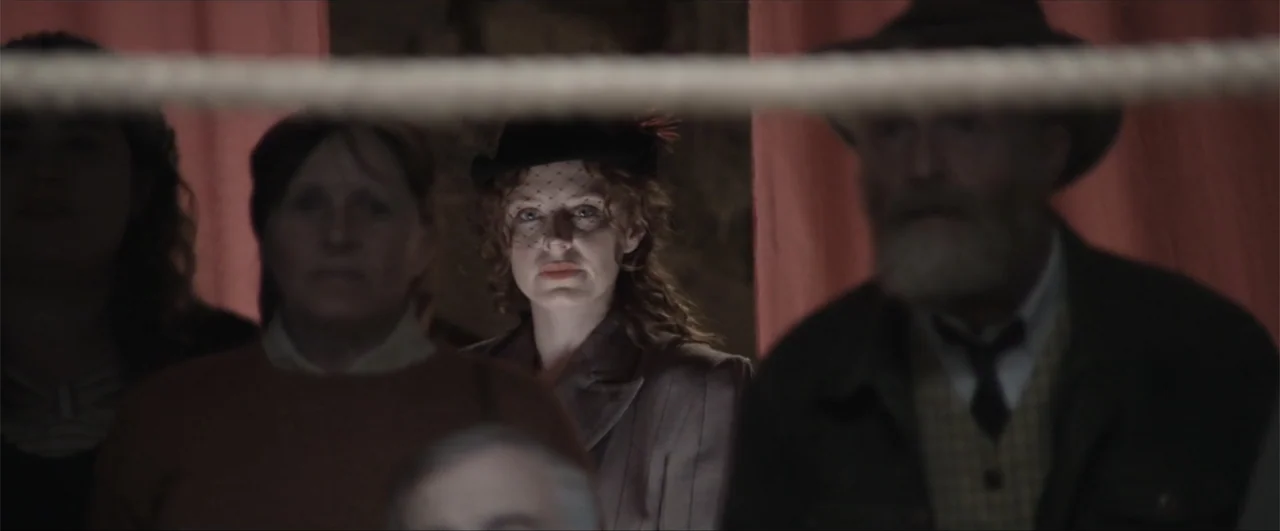 Behind the Line: Escape to Dunkirk (2020) movie still: medium — A group of people observe an event from behind a thick rope barrier. A woman in a…