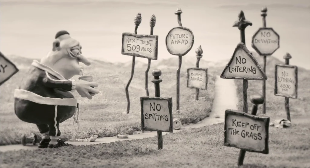 Mary & Max (2009) movie still: medium — A claymation environment features a path lined with numerous signs containing humorous instructions. A…