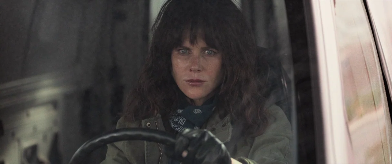 Destroyer (2018) movie still: medium — The interior of a vehicle during daylight hours with a blurred exterior landscape. A woman sits behind the…