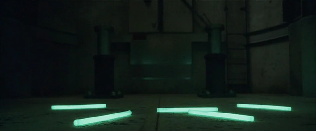 Ocean’s Eleven (2001) movie still: establishing — A dark, industrial concrete bunker interior features heavy metal machinery stands in the back.…