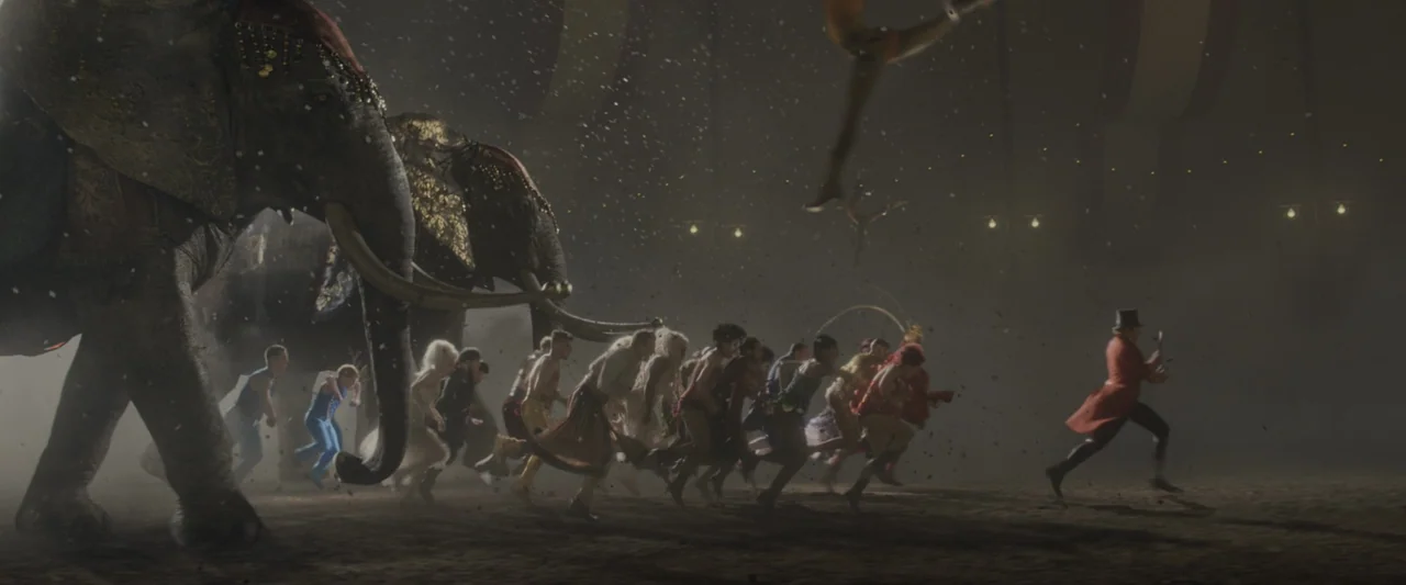 The Greatest Showman (2017) movie still: wide — A dark, dusty circus ring illuminated by dim lights high above the rafters. Performers and two…