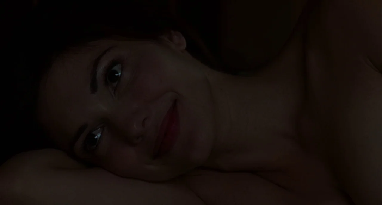 Mulholland Drive (2001) movie still: closeup — A person rests their head on a pillow in a darkened environment. The subject is partially illuminated…