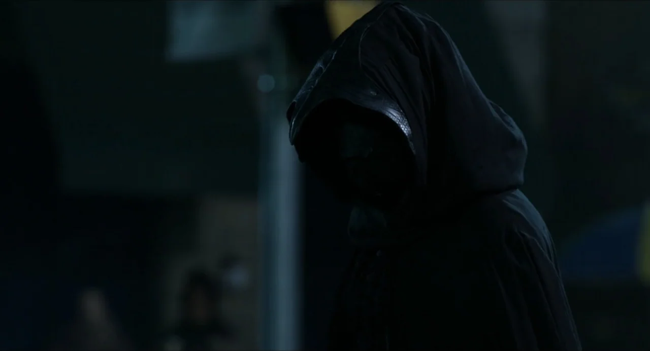 Henry Danger: The Movie (2025) movie still: medium — A dark outdoor urban setting at night provides the background for a hooded figure. A person…