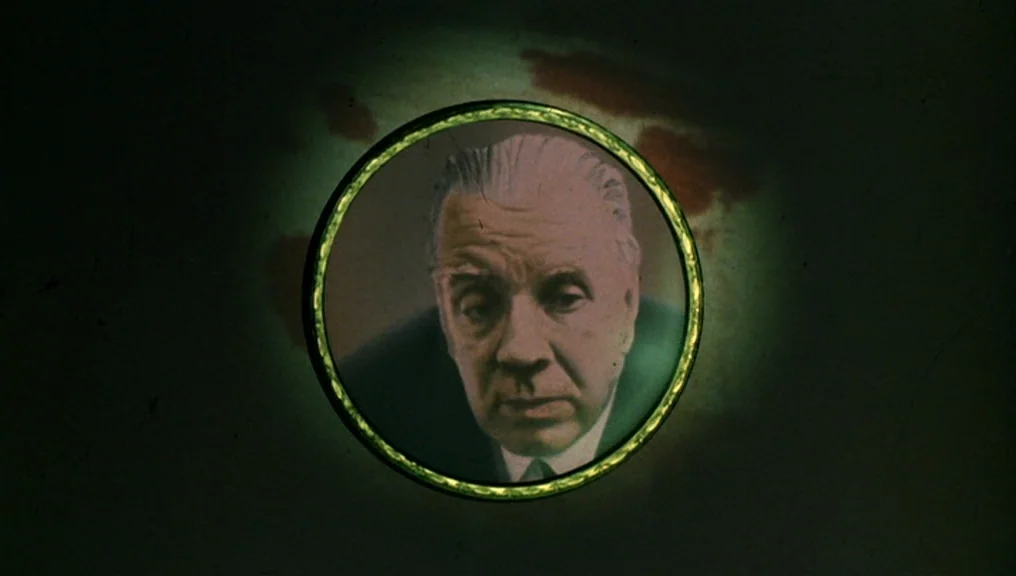 Performance (1970) movie still: closeup — An elderly man is framed within a circular vignette against a dark, textured background. The subject…