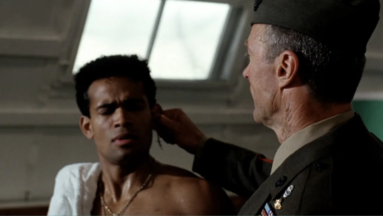 Heartbreak Ridge (1986) movie still: medium — A spartan military room features a window with daylight filtering through the glass. An older man in…