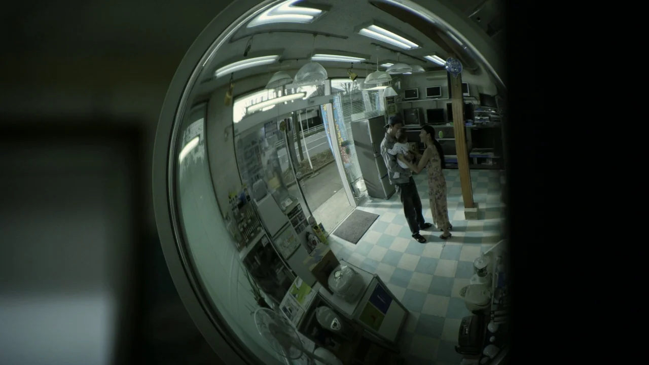 Confessions (2010) movie still: wide — A fish-eye view shows a retail store interior with checkerboard flooring and various consumer electronics. A…