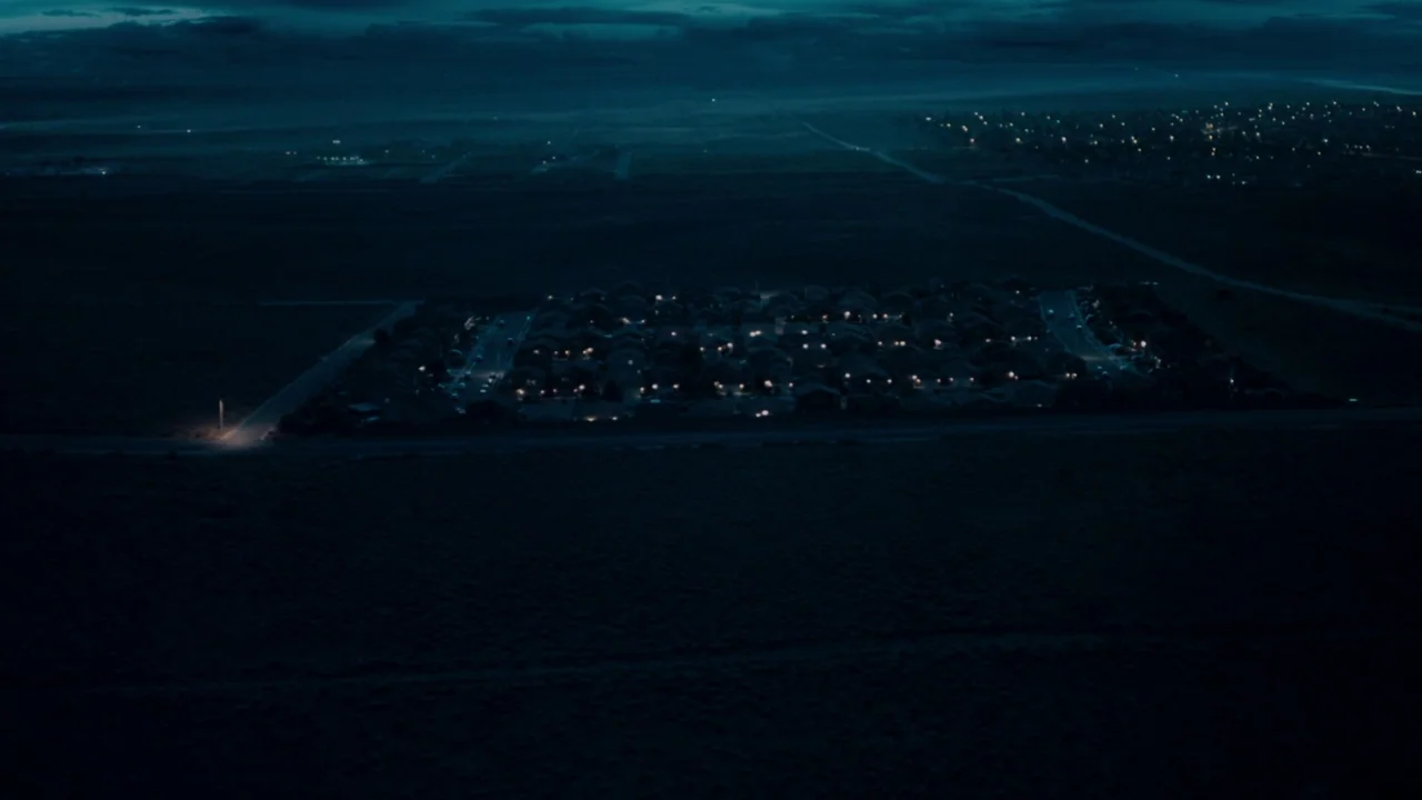 Fright Night (2011) movie still: establishing — An aerial view shows a small residential neighborhood isolated within a dark, rural expanse. A…