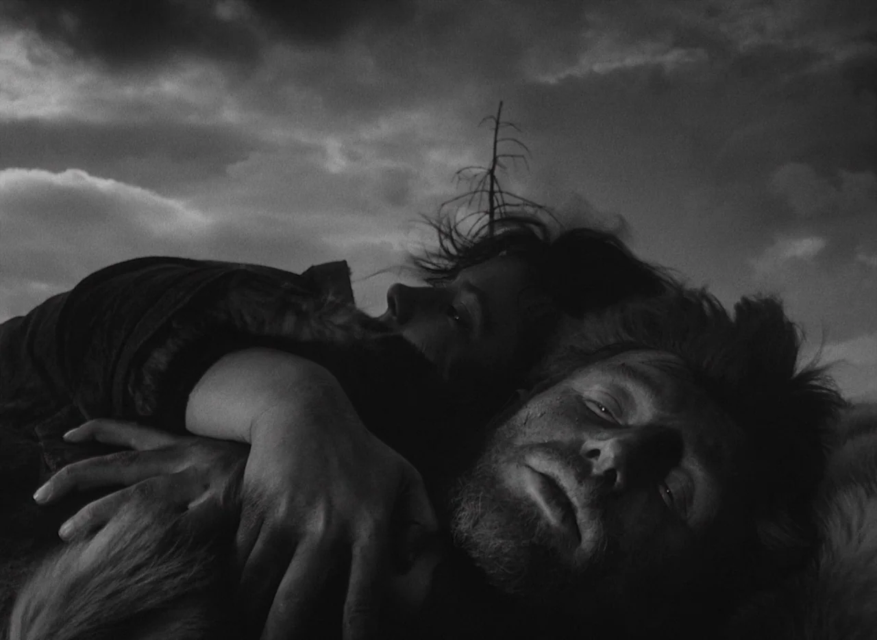 Letter Never Sent (1960) movie still: closeup — A field under a dark, overcast sky during the late hours of the day. A man and a woman lie closely…