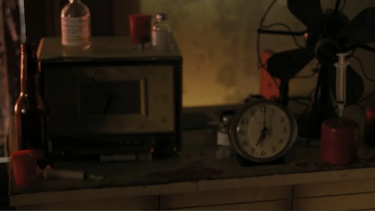 Mr. Brooks (2007) movie still: medium — A cluttered table holds medical equipment including glass vials and a vintage radio. Multiple syringes and…