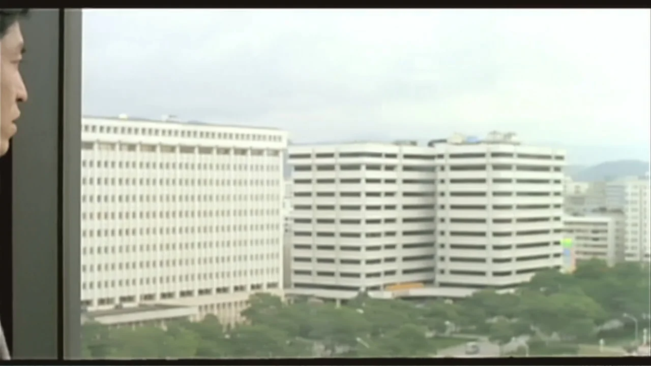 Flowers of Taipei: Taiwan New Cinema (2014) movie still: medium — A view from an interior office window overlooks large concrete multi-story…