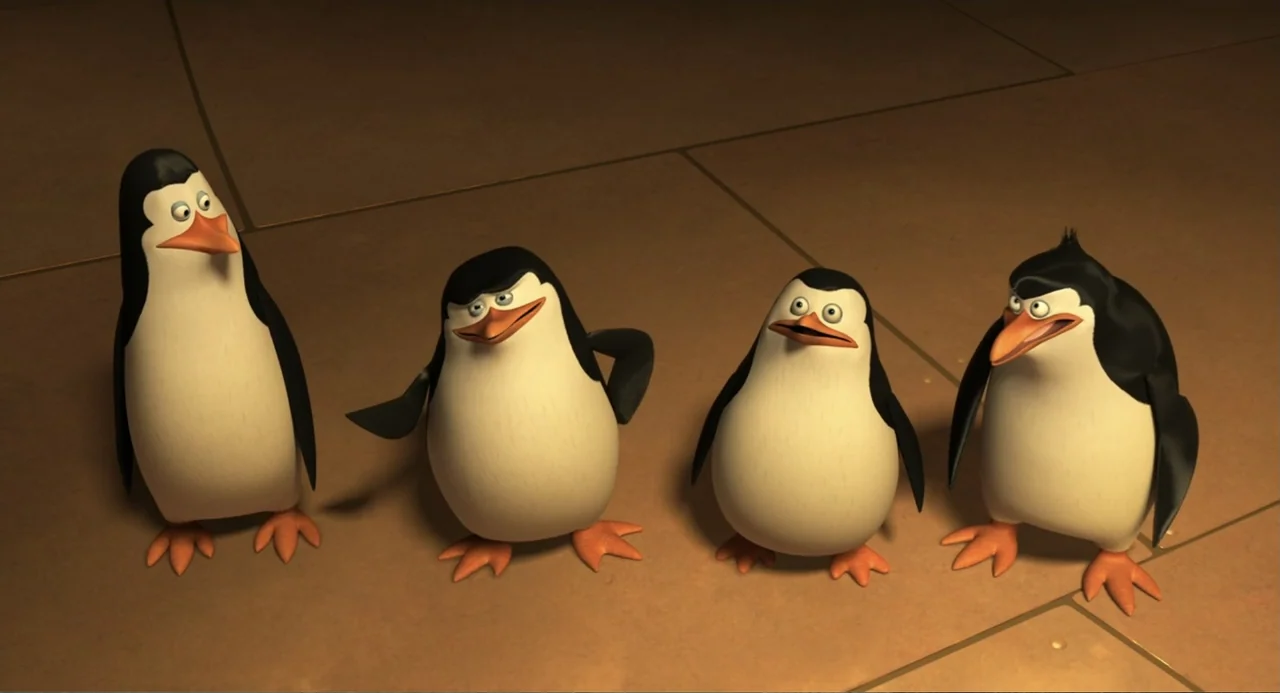 Penguins of Madagascar (2014) movie still: fullbody — Four stylized cartoon penguins stand together on a flat, beige-colored tiled floor surface.…