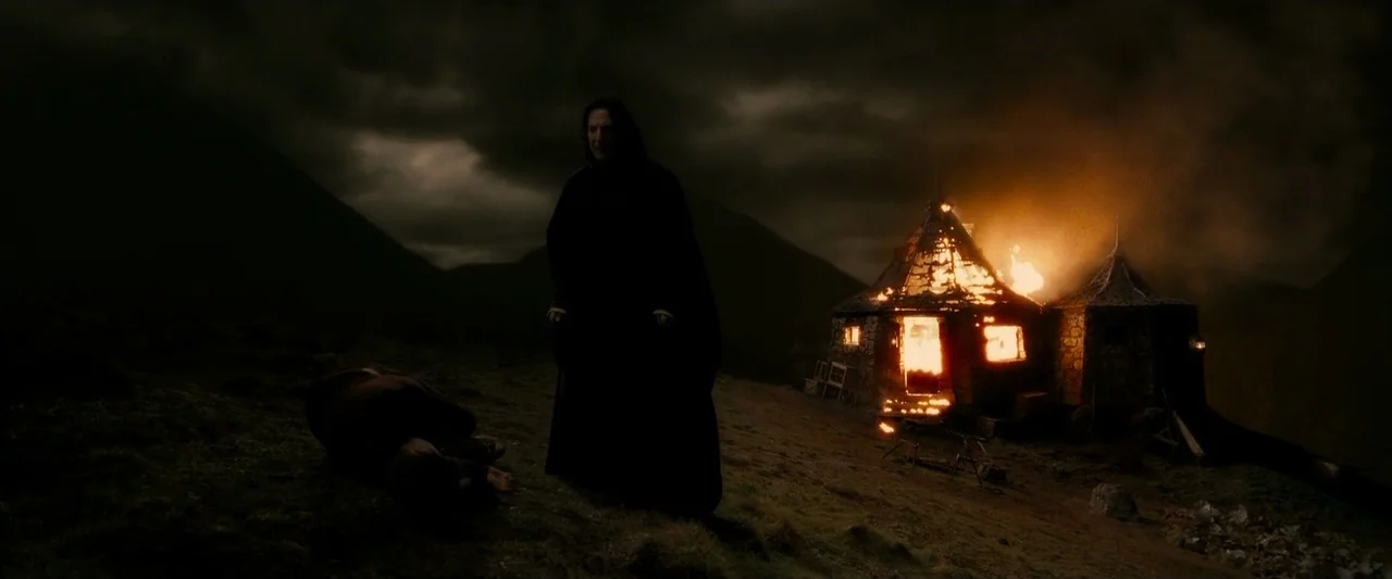 Harry Potter & The Half Blood Prince (2009) movie still: wide — A dark, hilly landscape is set at night under a cloudy sky. A man stands near an…