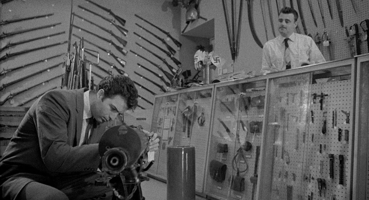 Murder By Contract (1958) movie still: medium — An interior space displays various military rifles and swords mounted on walls and cabinets. A…
